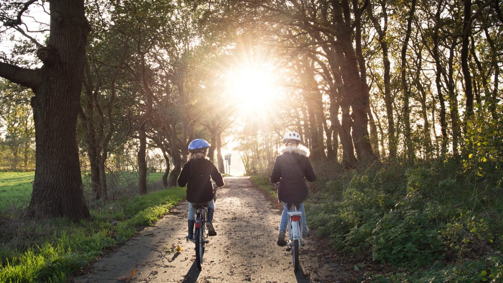 Two kids on bicycles on dirt trail